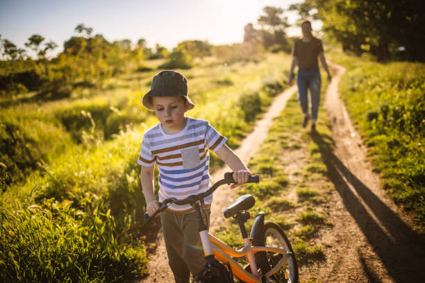 istock Mother with son riding a bicycle in nature 1320860177