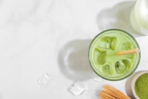 café con leche matcha verde helado en un vaso sobre fondo blanco con sombras duras. bebida fría de verano. vista superior - té matcha fotografías e imágenes de stock