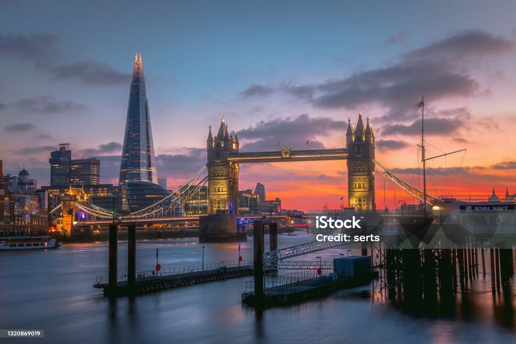 The Tower Bridge and Thames River at sunset in London, UK Beautiful during sunrise with illuminated buildings on the River Thames at Tower Bridge and Financial district in City of London, England. London - England Stock Photo