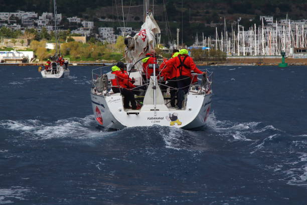 segelboote segeln bei windigem wetter im blauen wasser der ägäis - sailboat storm teamwork competition stock-fotos und bilder