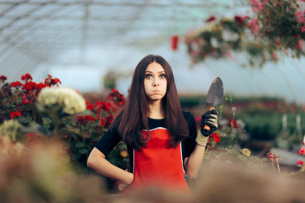 istock Stressed Greenhouse Worker Holding Gardening Tools 1320875662