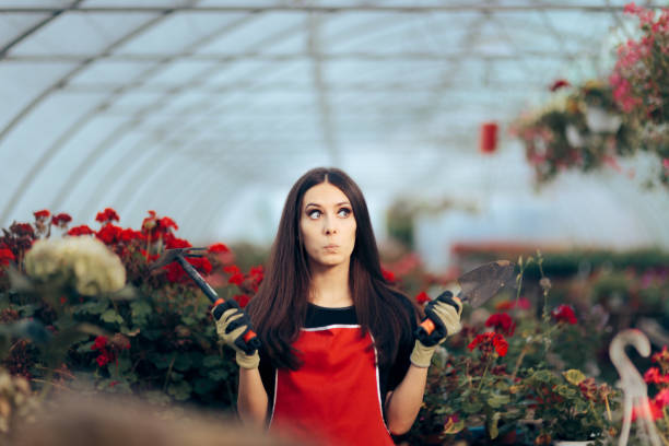 istock Stressed Greenhouse Worker Holding Gardening Tools 1320875667