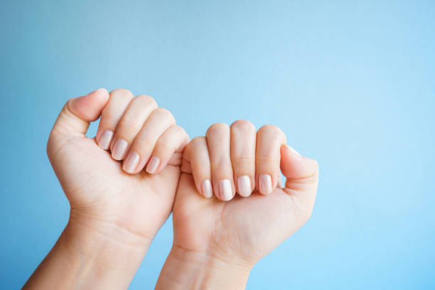 istock Close-up women's hands with a beautiful manicure isolate on blue background. 1320876674
