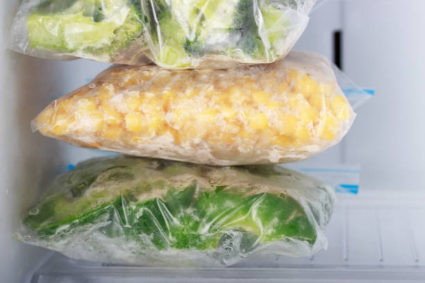 istock Frozen vegetables in bags in freezer close-up, front view 1320887758