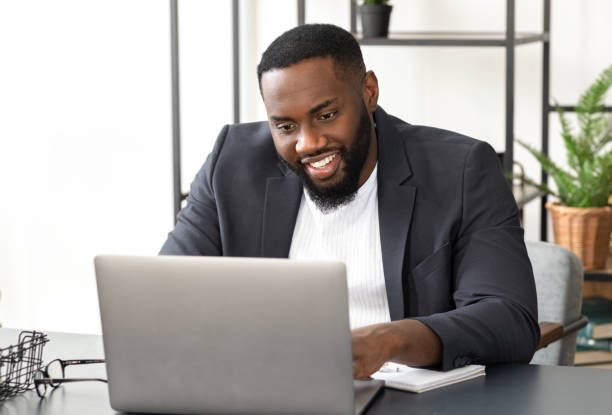 istock Successful young African American businessman using laptop for video communication with employees. Video conferencing or online education concept 1320888839