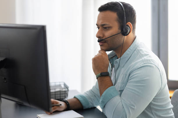 istock Portrait of focused employee support services. Serious man in headset with microphone working in office, video conference or video call 1320888842