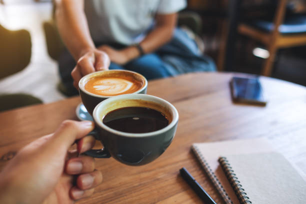 istock A man and a woman clinking coffee mugs in cafe 1320889656