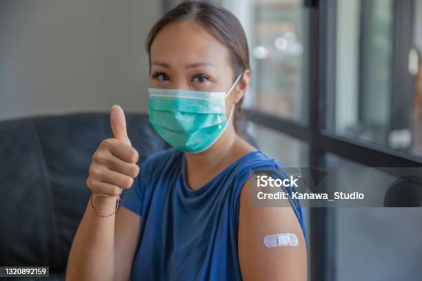 Proud Asian Woman Giving Thumbs Up After Receiving A Covid19 Vaccine Stock Photo - Download Image Now