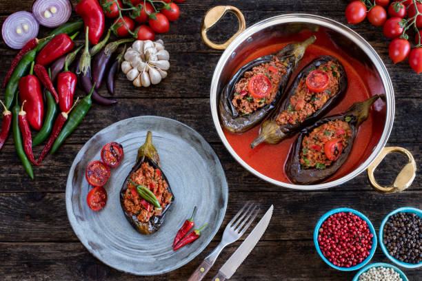 gevulde aubergine in het bord. aubergine maaltijd karniyarik of karnıyarık of imambayildi op tafel. - koperen pan stockfoto's en -beelden