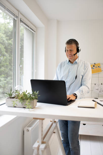 istock Man stands behind high table and speaks with headset 1320898129