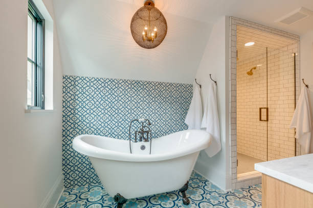 blue and white patterned tile in bathroom with free standing bathtub - badkamer fotos stockfoto's en -beelden