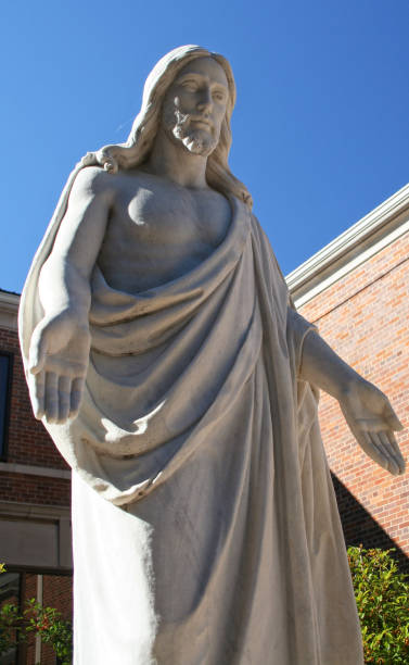 istock Jesus Statue and Church Steeple With sun 1320899124