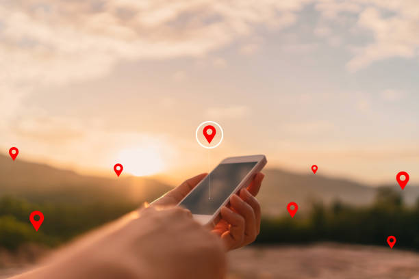 istock Man hand using smart phone on top of mountain with navigator location point abstract background. 1320900318