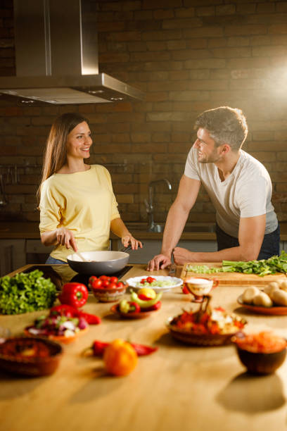 istock Happy couple talking while making lunch in the kitchen. 1320903212