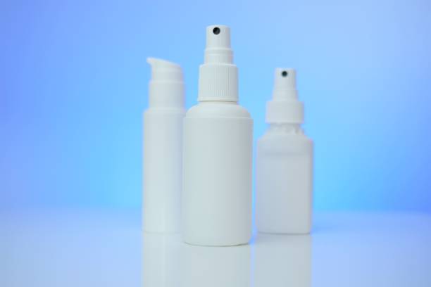 istock Hygiene and sanitation products. White bottles mock up on blue background.White blank bottles set with blue light. Medicine and hygiene concept. sanitation products. 1320904041
