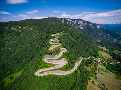 Winding spectacular hairpin curve mountain pass road Strma Reber, Kocevsko, Slovenia. Reminds of human colon digestive tract system. Drone from above stock photo 4K UHD drone-made photography. Environment. High quality image