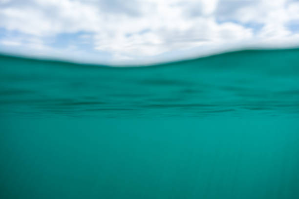 istock Blue water below the waves and a cloudy sky above the surface 1320909492