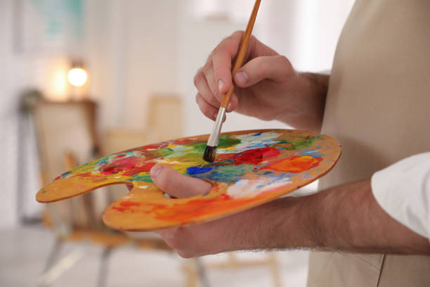 アーティストスタジオで絵画ブラシとパレットを持つ若い男、クローズアップ - artists canvas palette paintbrush oil painting ストックフォトと画像