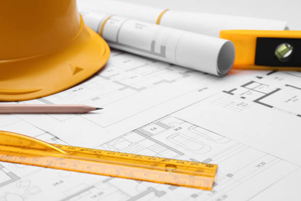 istock Pencil, ruler and hardhat on blueprints, closeup 1320910889