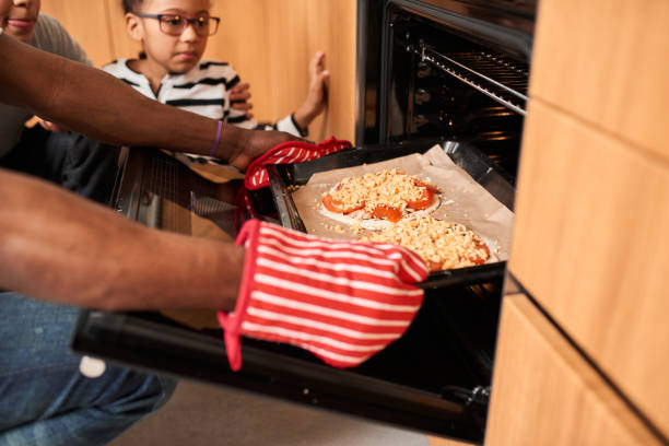 istock Multiracial man is baking pizza with his lovely multiracial daughters 1320914710