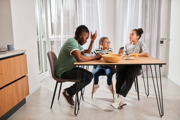 istock Children having breakfast with appetite and looking into their father 1320914714