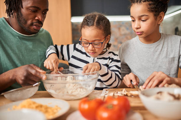 istock Father looking attentively at his daughters while spending time together at the kitchen 1320914780