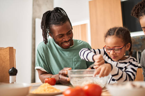 istock Father helping to his daughter adding and mixing ingredients in dough 1320914789