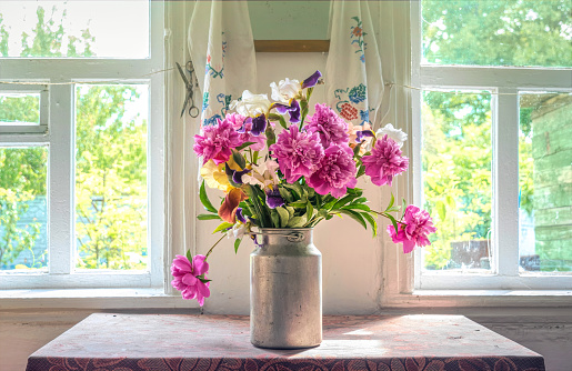 Old window and a bouquet of pink peonies