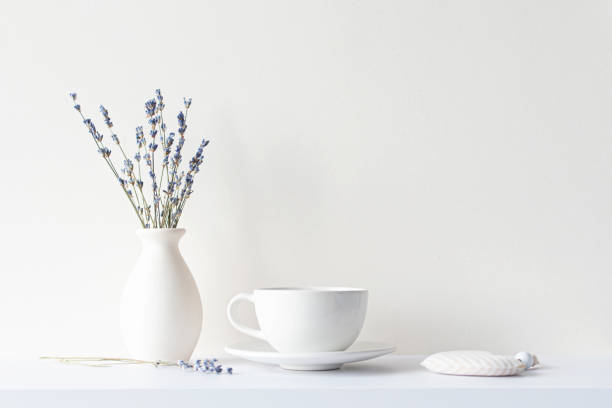 istock Still life with minimal composition, lavender dried bouquet, ceramic white cup and hot beverage tea or coffee, morning mood in beige tone 1320917120