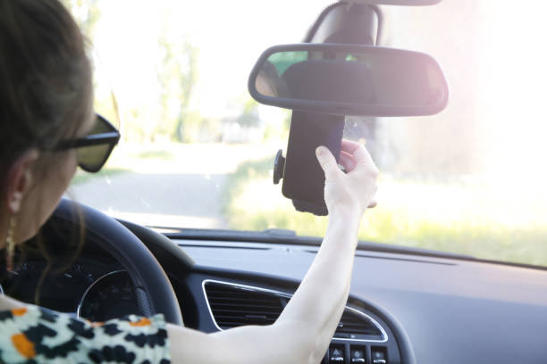 istock Woman inserting her cell phone in car phone holder 1320917388
