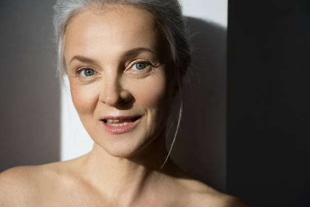 istock Senior woman looking at the camera with light smile while posing at the studio 1320918361