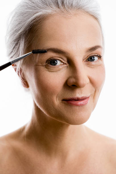 istock Mature woman is using brush while taking care of her brows 1320918380