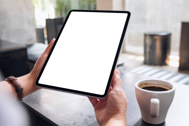 istock a woman holding digital tablet with blank white desktop screen in cafe 1320918483