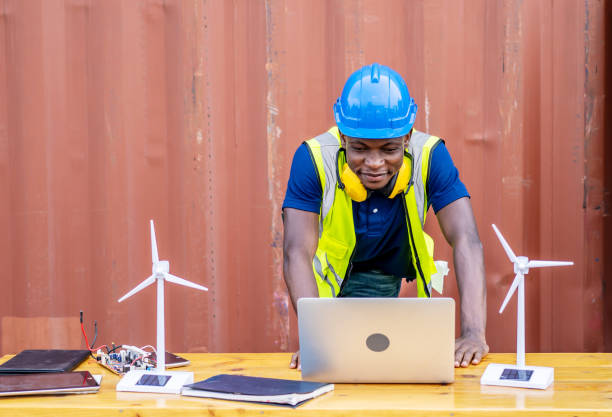 istock Ecology engineer typing on laptop and working on project. On desk are windmill models. Sustainable development concept 1320922734