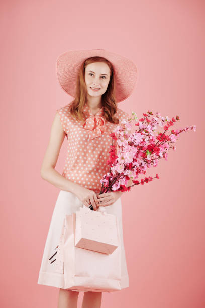 istock Young woman holding blooming branches 1320922876