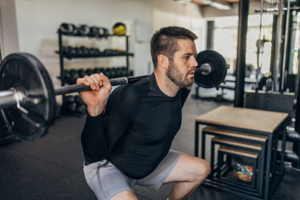 istock Man exercising with weights in gym 1320923254