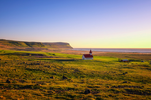 Sunset at the Breidavik church located at the sand beach in Westfjords, Iceland