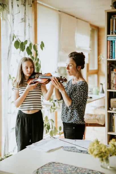 madre e hija pasando tiempo juntas en casa - violin family fotografías e imágenes de stock