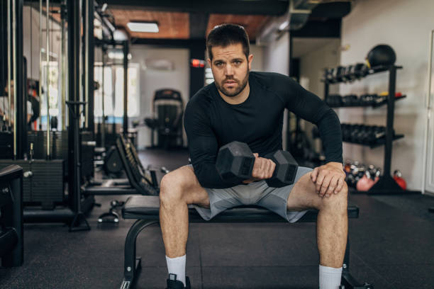 istock Man exercising with dumbbell in gym 1320924167