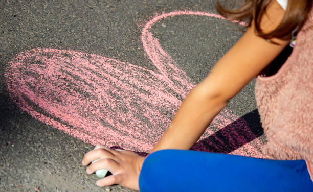 istock Cute little child draws with chalk outdoors, summer time, chalk. Selective focus. 1320924271