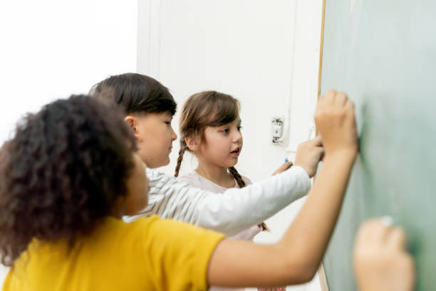 istock Diverse kids drawing on chalkboard during lesson 1320924400