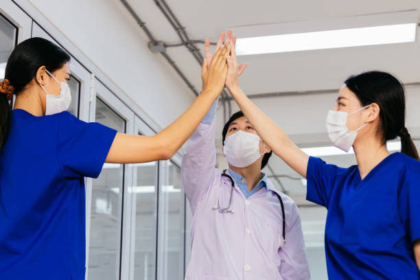 ärzteteam gibt hohe fünf - nurse high five mask stock-fotos und bilder