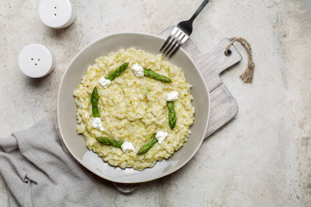 istock Rice dish - risotto with asparagus and soft cheese. Stone background. Flat lay, copy, space. 1320926220