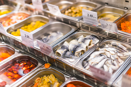 Marinated food products put up for sale in a supermarket commercial refrigerator