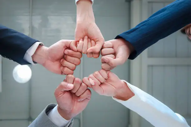 Businessman and woman putting hands fist join together, business partnership colleagues holding hands as commitment of strong team work, unity and teamwork Join hands support concept.