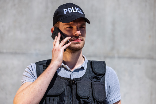 Portrait Of A Police Officer Using Smart Phone