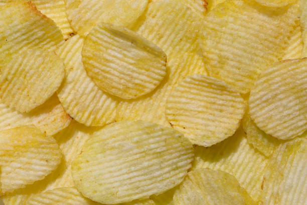 istock Close-up of potato ribbed chips. Chips background 1320927728