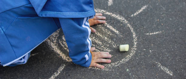 istock Cute little child draws the sun with chalk outdoors, summer time, chalk. Selective focus. 1320928029