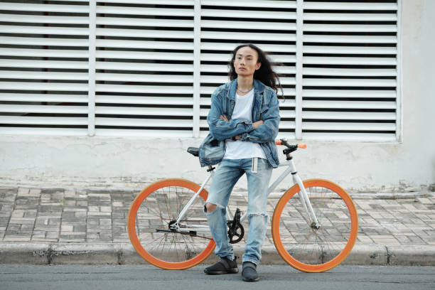 istock Confident Asian bicyclist in denim wear 1320928679