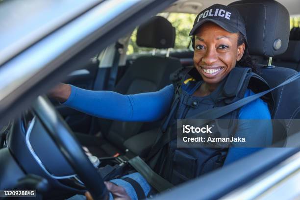 Policewoman Sitting In The Police Car And Looking At Camera Stock Photo - Download Image Now